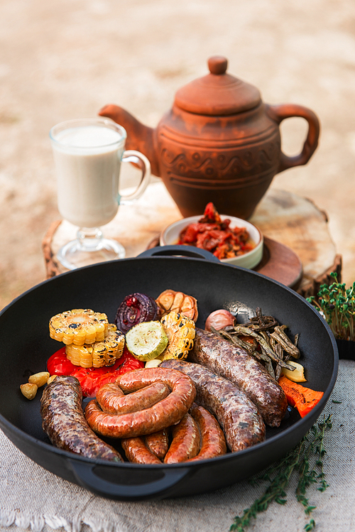 Grilled different meat sausages with vegetables and spices