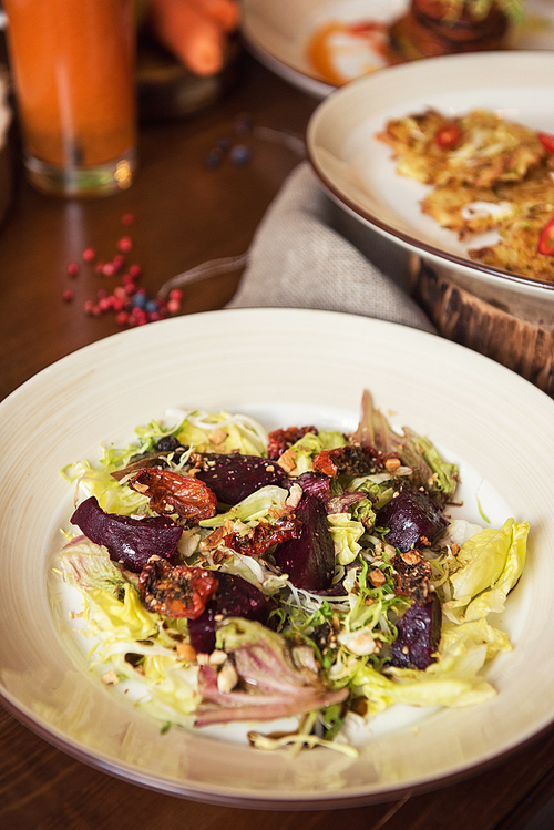 healthy vegeterian food on brown wood board. spring vitamin ing food. salad from beet with dried tomatoes and cabbage