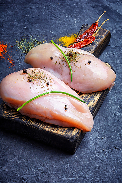 Raw chicken meat on the kitchen cutting board