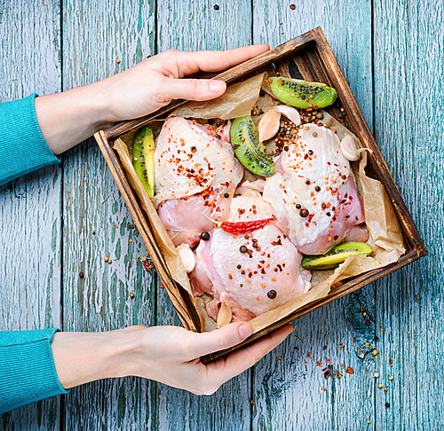Raw chicken breast in spices on a wooden tray.Chicken meat
