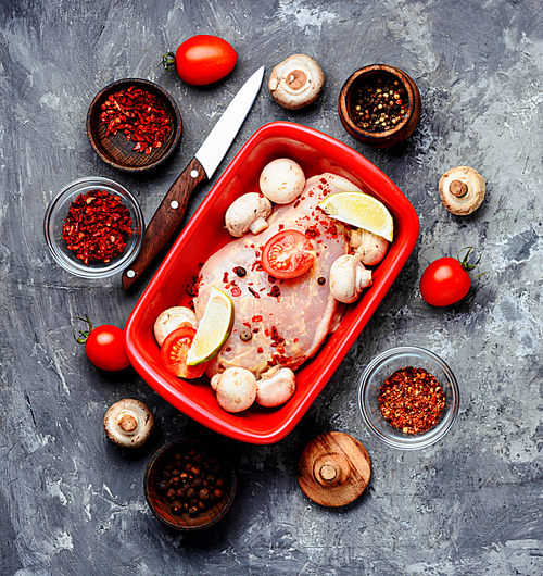 Raw chicken meat with mushrooms in a baking dish.Ingredients for cooking
