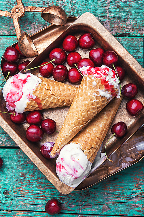 Summer vanilla ice cream in waffle cones and cherry berries