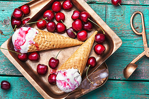 Summer vanilla ice cream in waffle cones and cherry berries