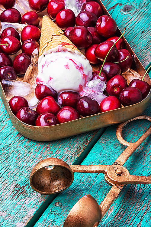 vanilla ice cream in waffle cones and cherry on rustic wooden table