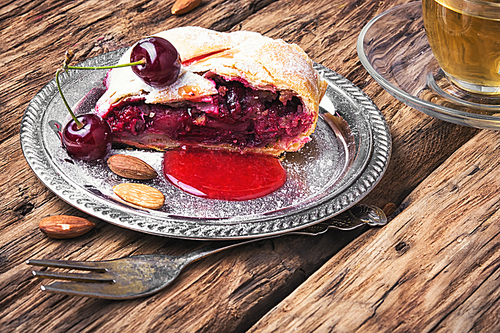 Traditional puff pastry strudel with berries of cherry