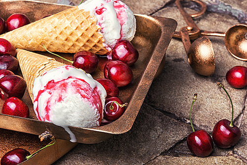 Ice cream in a waffle with cherry jam on a stylish stone background