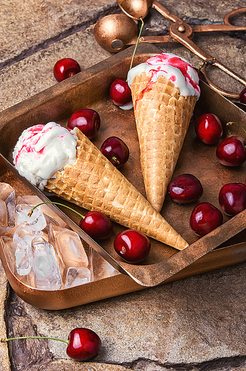 Ice cream in a waffle with cherry jam on stylish stone background