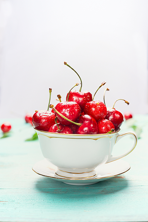 Cup full of ripe sweet cherries on light background, close up. Summer fruits and berries concept.