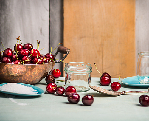 Cherries berries preserving with glass jar on rustic kitchen table, over wooden background