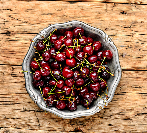 Fresh cherries in bowl on wooden background.Sweet cherries