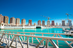 Luxury residential buildings of Pearl-Qatar and white yachts at Porto Arabia marina. Doha, Qatar
