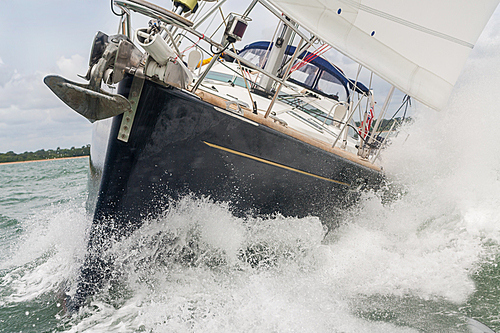 Close up of sailing boat, sail boat or yacht at sea with white sails