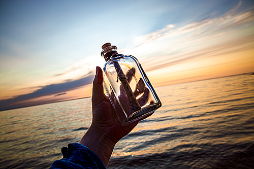 Message in the bottle against the Sun setting down