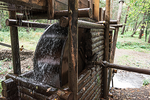 Rustic watermill with wheel being turned by force of falling water from Altai mountain river.