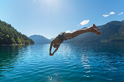 Man jumping in lake at summer season