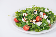 Green salad with vegetables: greens, arugula, tomato, cheese, pine nuts and sauce