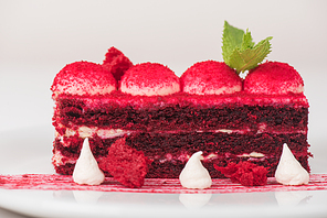Plate with piece of delicious red velvet cake on white background
