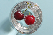 Glass of water and fresh cherries with bubbles