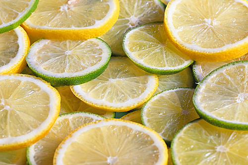 Fresh green and yellow lemon slices background