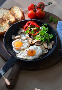 fried eggs and s in a frying pan