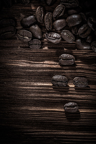 Heap of coffee grains on wooden board.