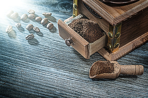 Coffee grinder grains on vintage wooden board.