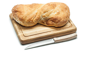loaf of sweet bread on carving board and kitchen knife isolated