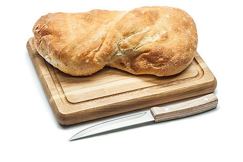 loaf of sweet bread on carving board and kitchen knife isolated