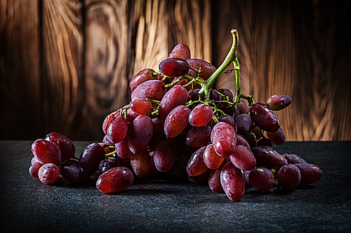 grape on wooden cutting board and brown gradient background