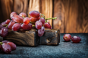 rose grape little branch on vintage carving board and wooden background