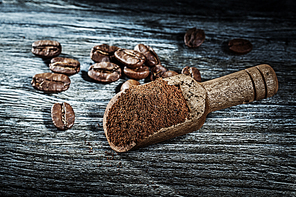 Coffee scoop beans on wooden board top view.