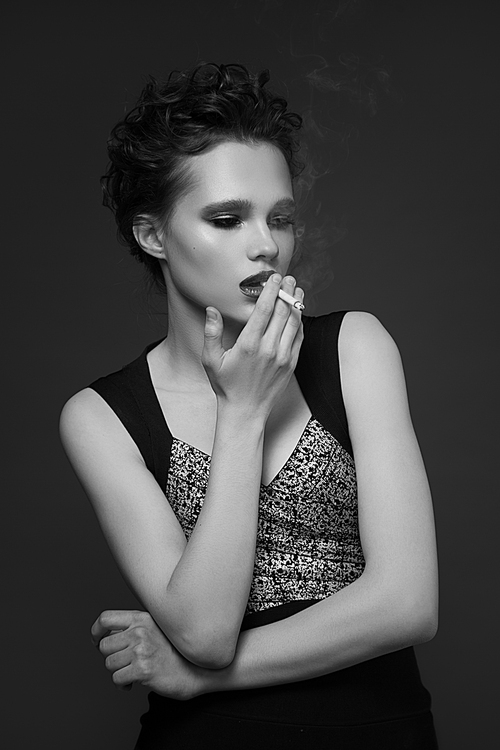 Fashion portrait of young woman smoking cigarette