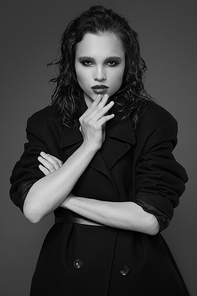 Fashion portrait of young woman in black coat