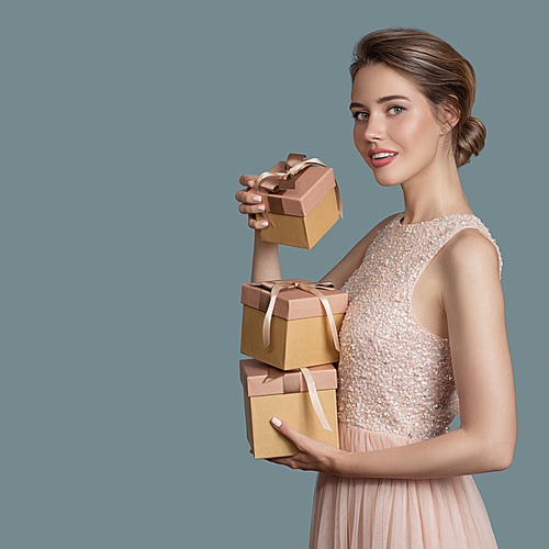 Beautiful woman holding gift boxes in her hands. Space for text.
