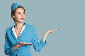 Charming stewardess on blue background. Direction sign.