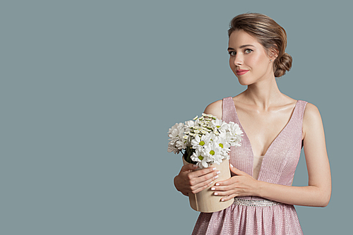 Beautiful woman holding chamomile flowers.