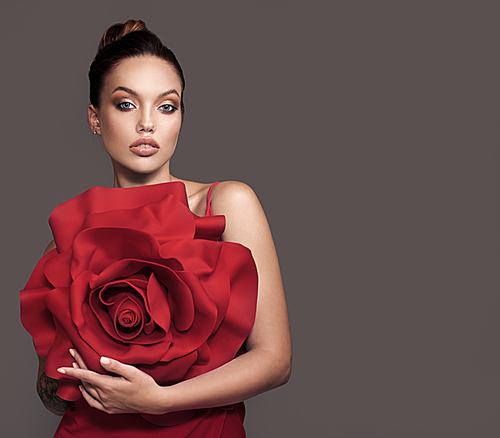 Beautiful woman holding big red rose in her hands.