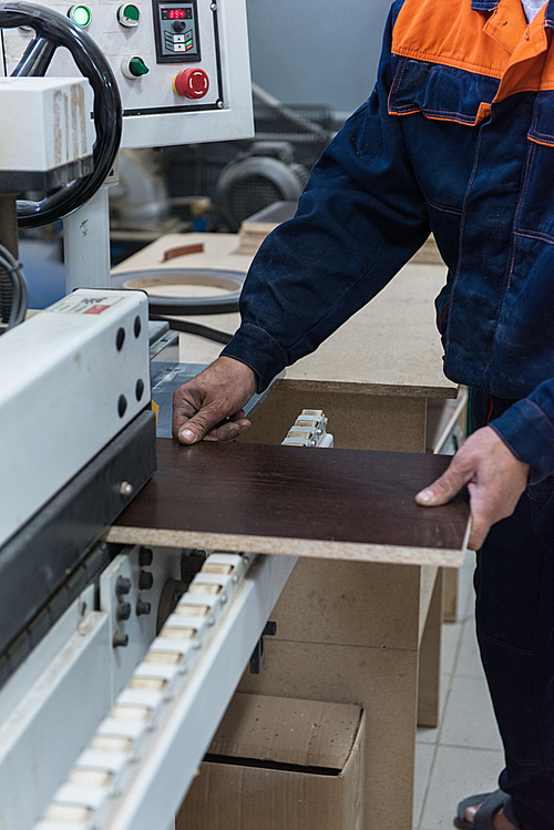 Furniture production or craft concept: worker making the wood surface of furniture part with special machine