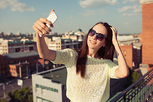 Young woman tourist taking selfie. Urban background.