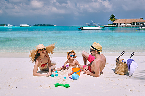 Family on beach, young couple with three year old boy. Summer vacation at Maldives.