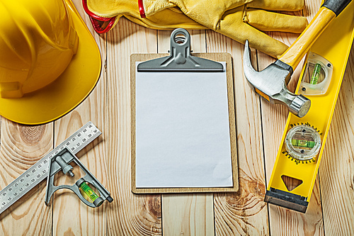 blank paper sheet for your text in clipboard and construction tools on wood
