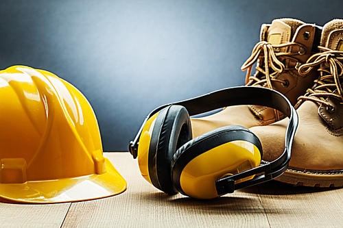 yellow construction earphones helmet and working boots