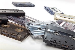 Pile of compact audio cassette tapes on a white background