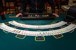 Professional croupier during cards shuffle in the casino