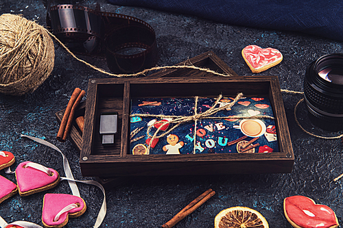 Wooden photo box with photo for Valentine's Day or Wedding Day. Decorated with gingerbreads. Romantic or love concept. Gingerbreads for Valentines Day on dark concrete background
