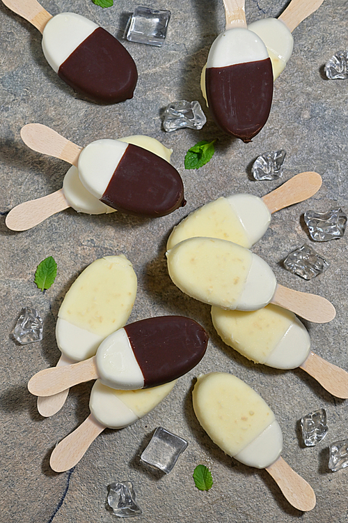 Ice cream in chocolate and white chocolate glaze on a stick