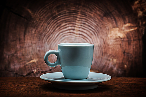 single white ceramic coffee cup on saucer vitage wood cross sected background