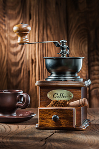 vertical view vintage wooden coffee mill with little scoop and cup on wood background