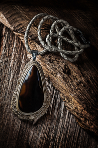 pendant with dark gem on vintage wood