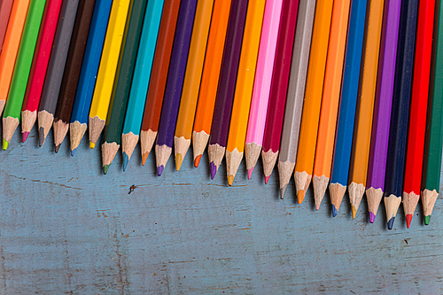 Wooden colorful pencils, on a blue old table